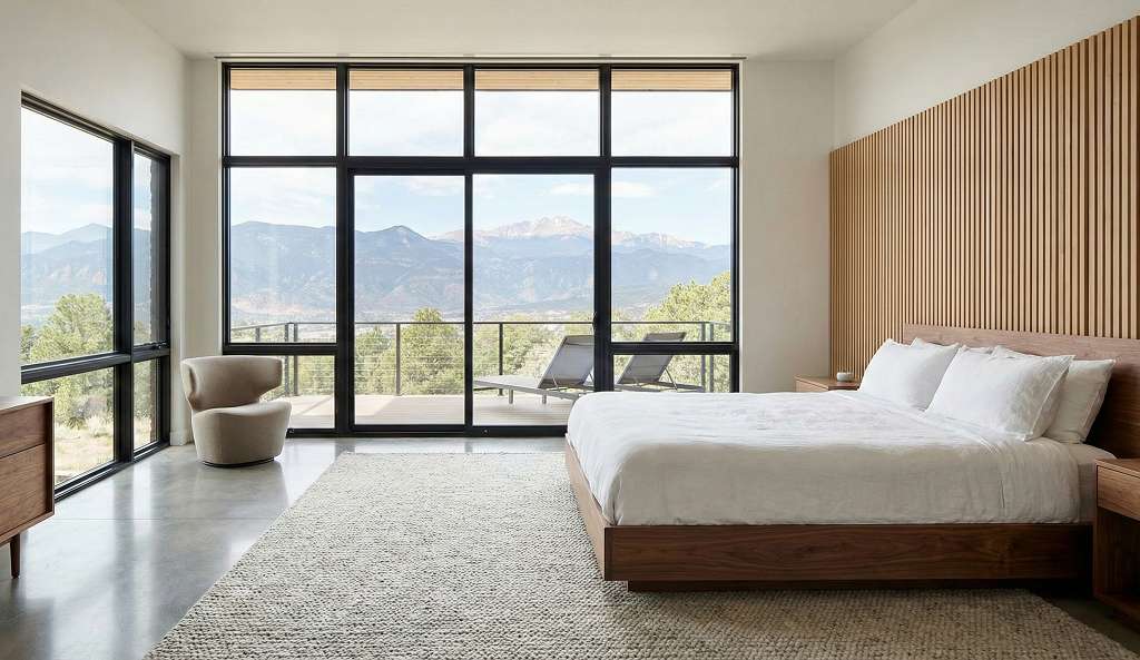 Master bedroom in Colorado modern mountain home with windows and Pikes Peak views