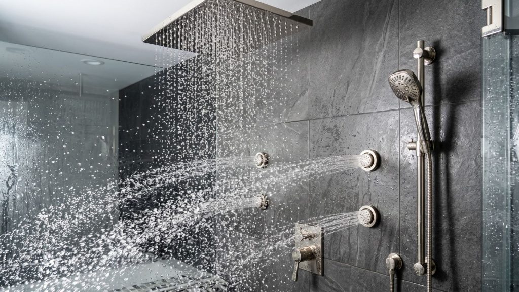 Advanced master bathroom renovation ideas featuring a ceiling-mounted rain head and wall-integrated body jets.