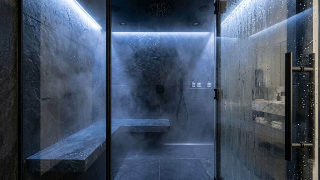 A high-end spa bathroom design featuring an enclosed steam shower with built-in seating and wellness lighting.